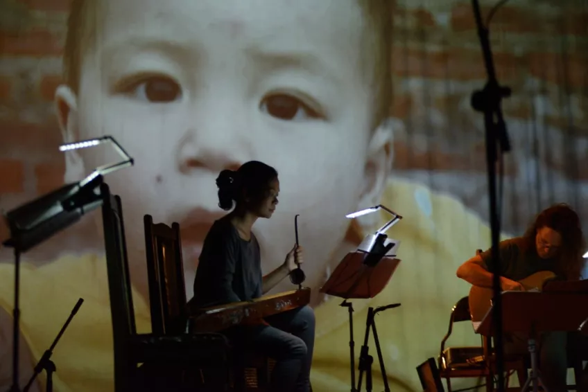 Concert infront of a projection with a child. Photo.